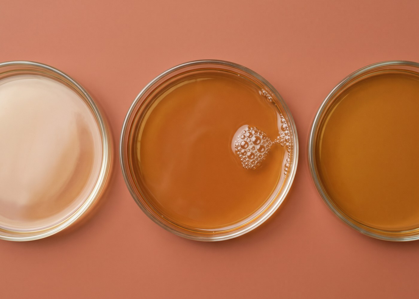 Drei flache Glasschalen von oben, in jeder die Peelinglösung in einer anderen Stärke von hell bis kräftig