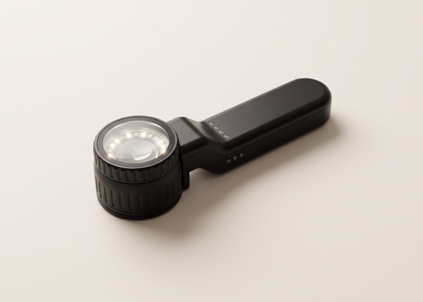 Schwarzes Dermatoskop liegt auf heller Fläche, im Optikkopf leuchtet ein Ring kleiner Lichter um die Linse