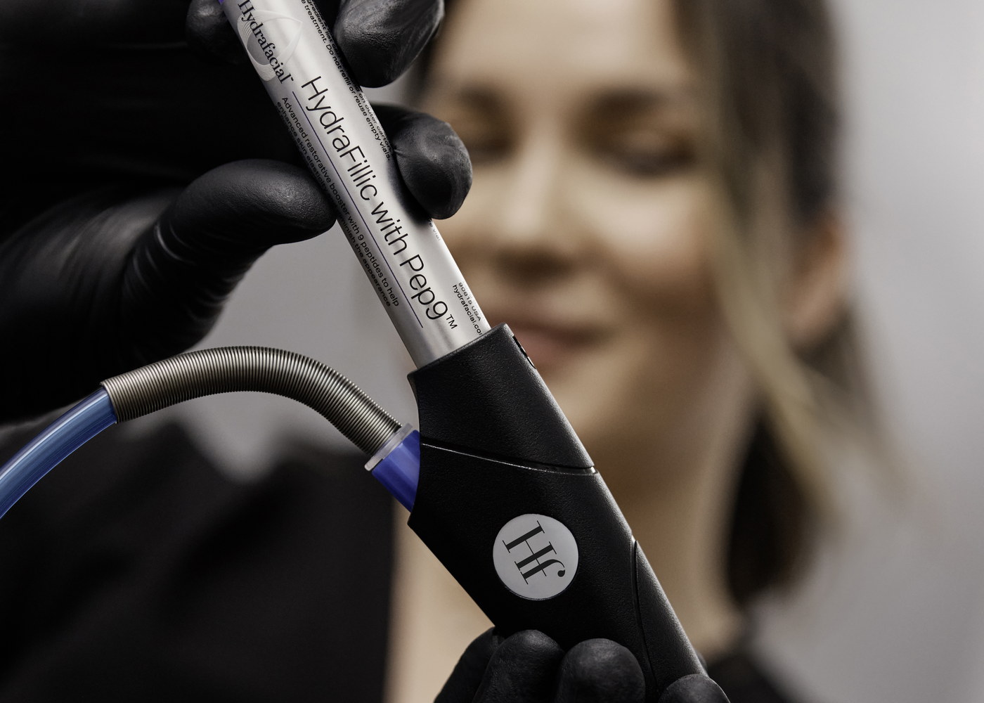 Behandschuhte Hand setzt eine Serumkartusche in das HydraFacial-Handstück ein