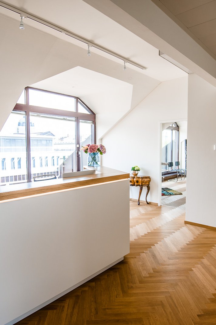 Blick über den Empfangstresen in die Praxisräume, Tageslicht durch die Fensterfront, Fischgrätparkett