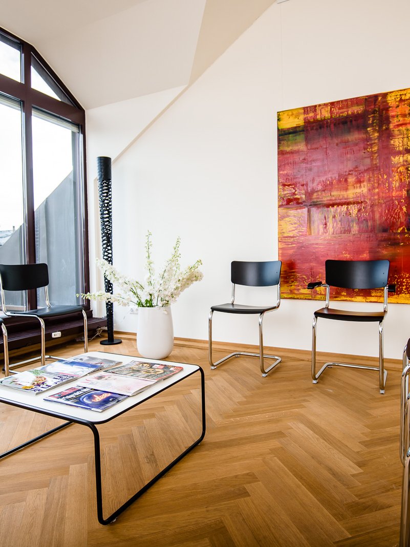 Wartebereich unter der Dachschräge, Stühle an der Fensterfront, Tisch mit Zeitschriften
