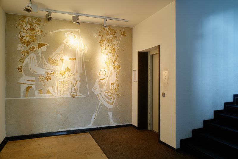 Das Foyer des Brauerhauses mit großem Wandbild und der Tür des Aufzugs